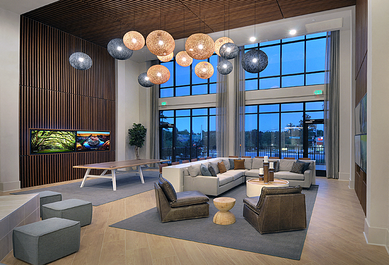 a living room with couches and chairs and large windows